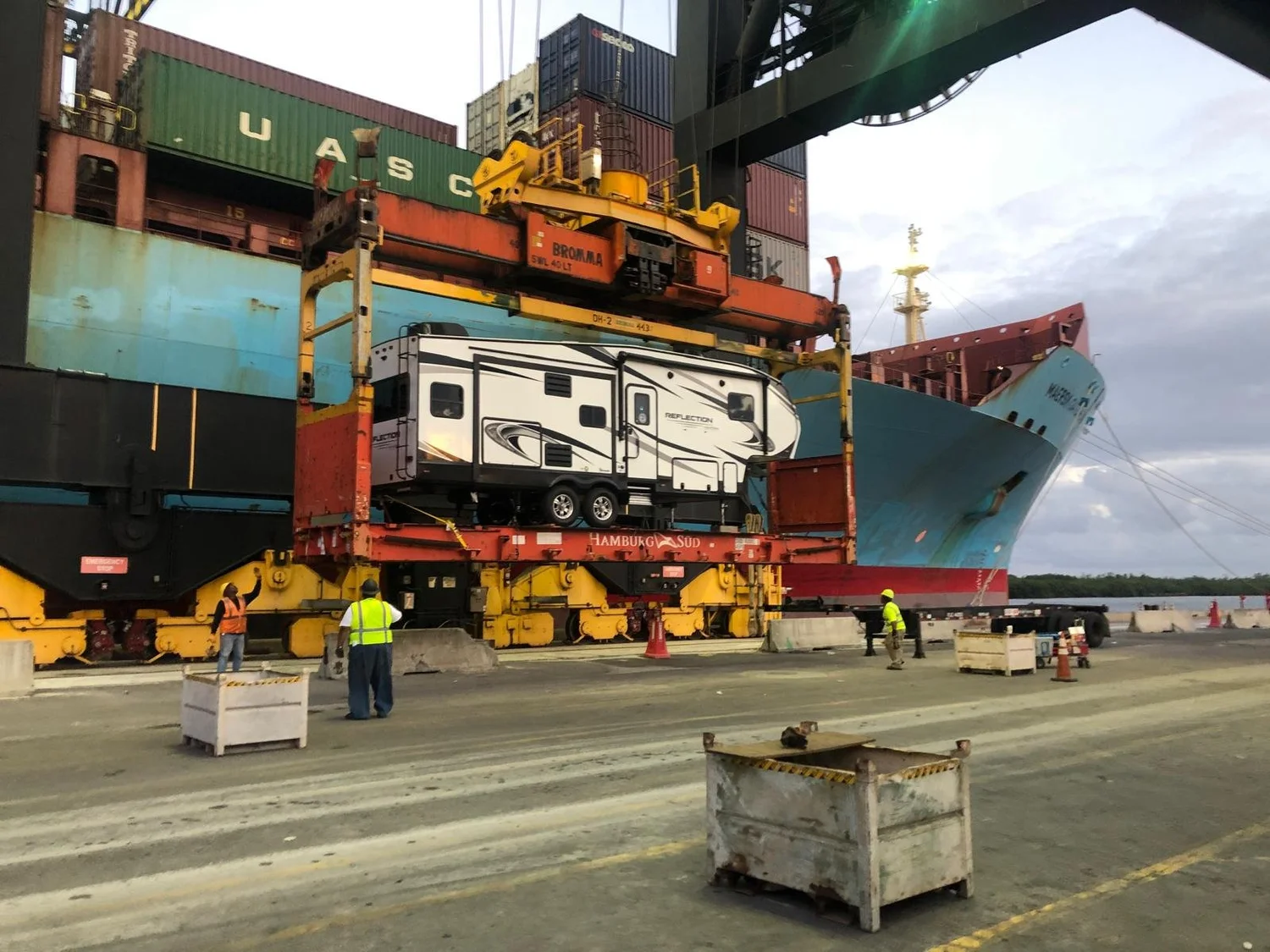 motorhome+loaded+on+flat+rack+container+being+lifted+onto+cargo+vessel+at+port+terminal+for+international+shipping